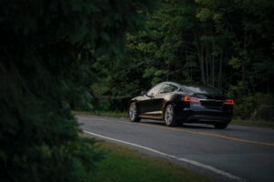 Black electric car on a forest road