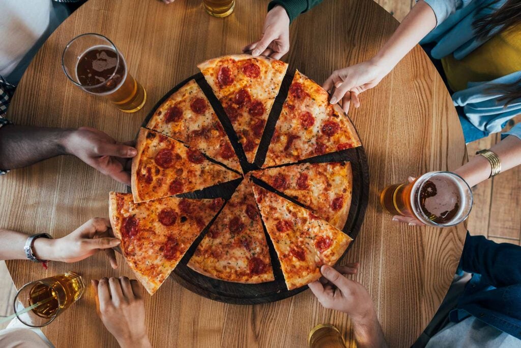 A pizza on a table with friends